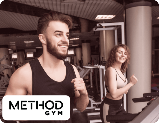 A man and a Woman are currently on a treadmill exercising.